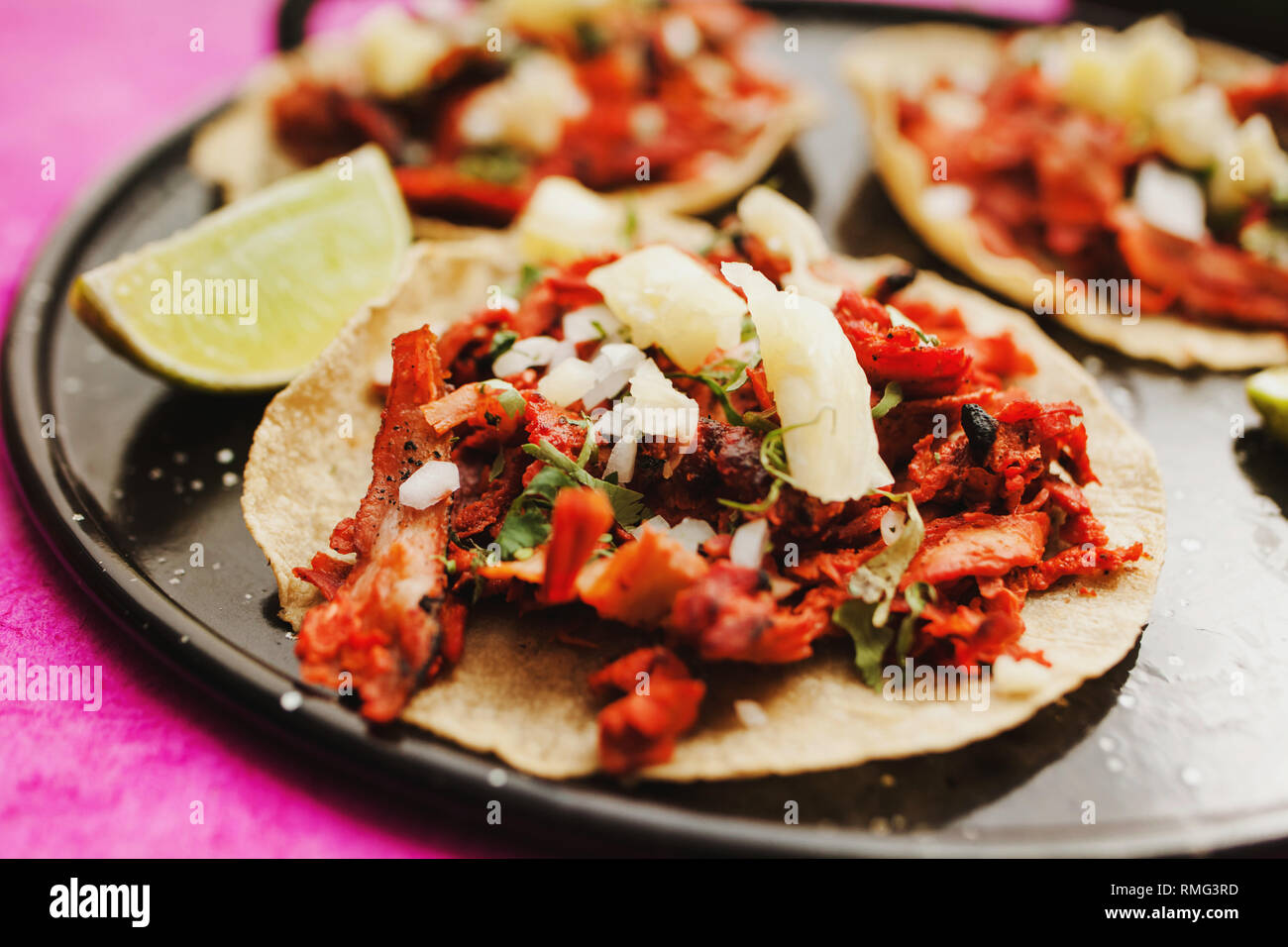 Pfeffer und Kalk in der Nähe von Tacos al Pastor und Saucen Stockfoto