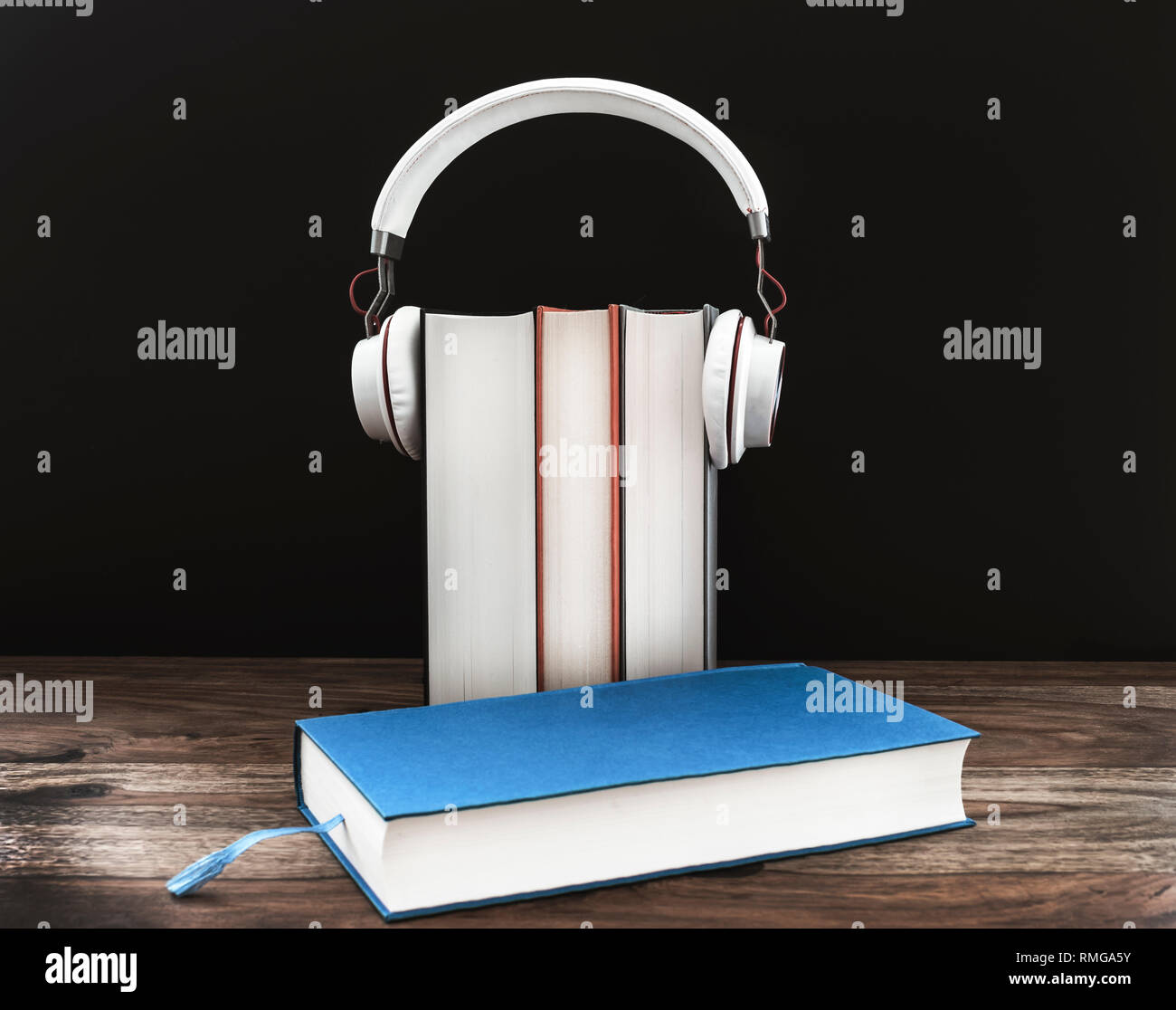 Hörbuch Konzept mit Kopfhörer auf gebundene Bücher gegen den dunklen Hintergrund Stockfoto