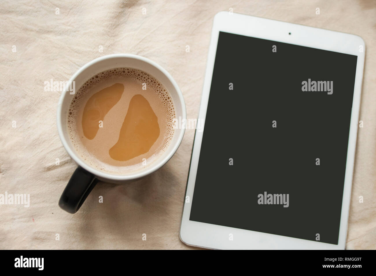 Morgendliche routine Konzept. Eine Tasse Kaffee und Tablet mit Copyspace.. Stockfoto