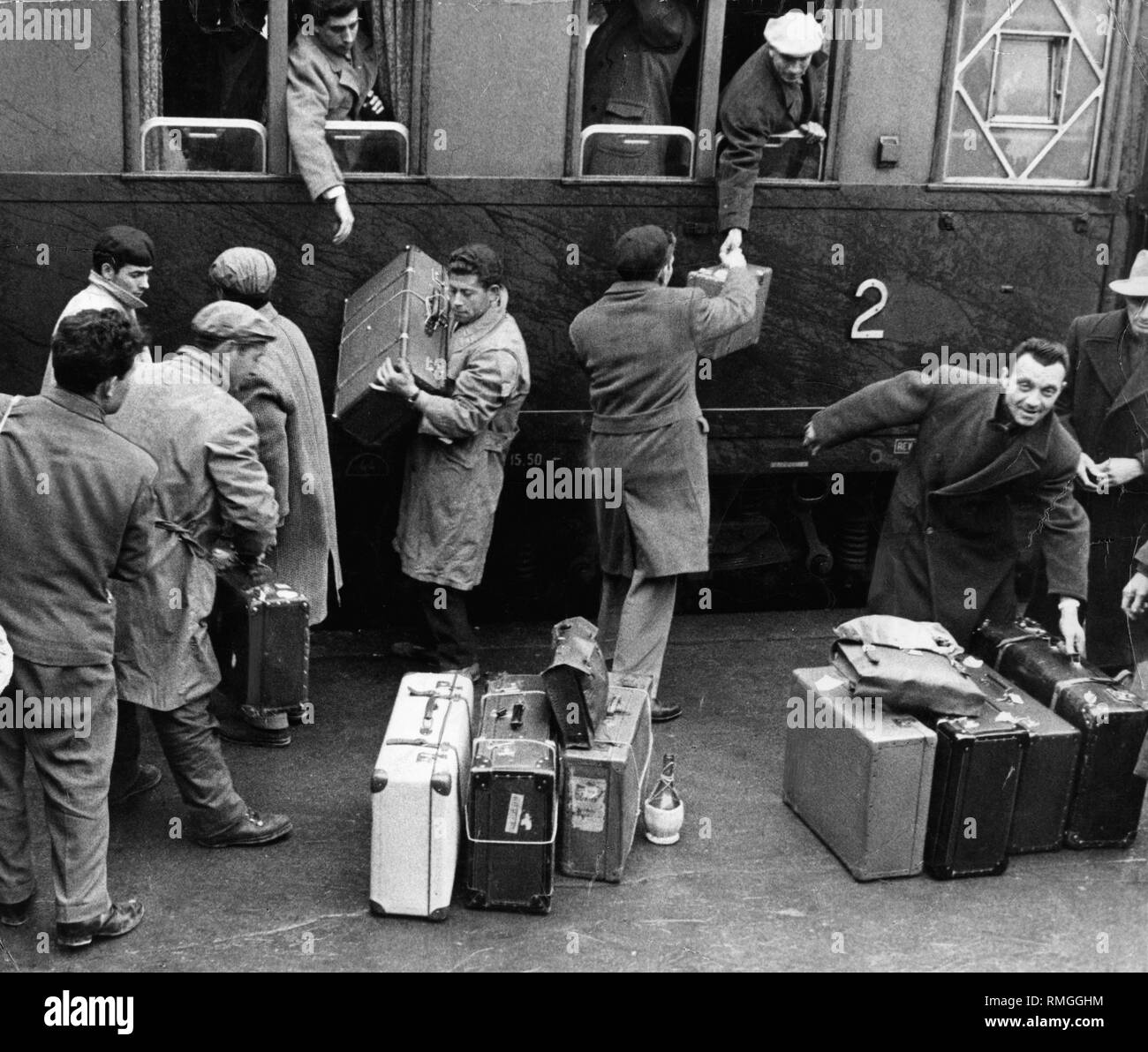 Italienische Gastarbeiter entladen Ihr Gepäck vom Bahnhof. Stockfoto