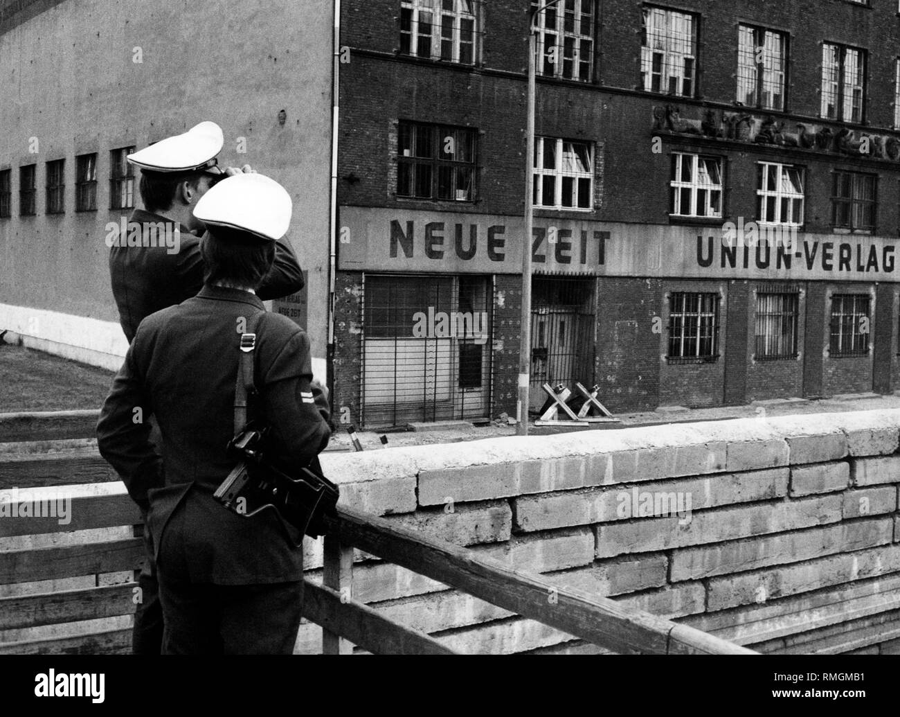 Undatiertes Bild des Verlags Union-Verlag, der Herausgeber der "Neuen Zeit" der Ost-CDU direkt an der Wand, im Vordergrund West-Berliner Polizisten. Stockfoto