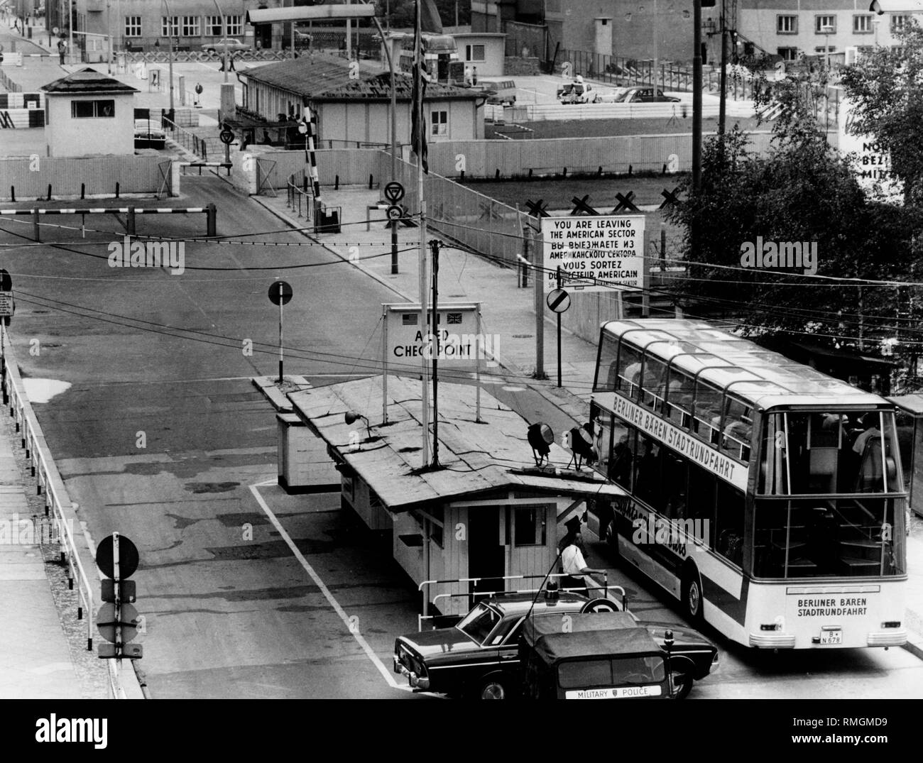 Undatiertes Foto der beiden Seiten des Checkpoint Charlie mit einem Bus der 'Berliner Bären Stadtrundfahrt". Stockfoto