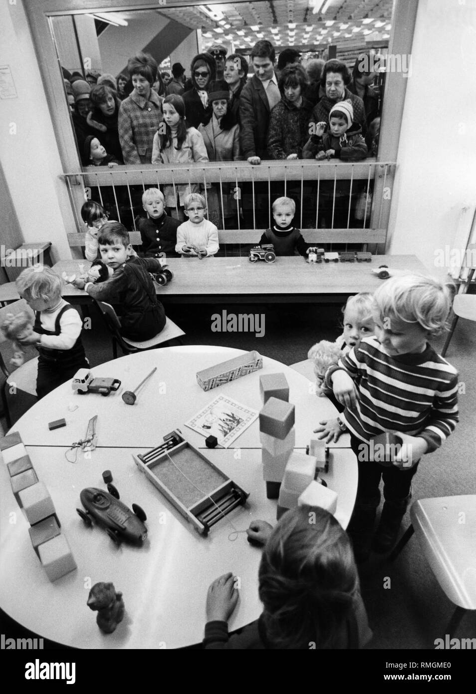 In einem Laden der Warenhäuser Centrum der DDR, die Kinder sind beschäftigt mit Spielzeug unter den Augen ihrer Eltern. Undatiertes Foto. Stockfoto