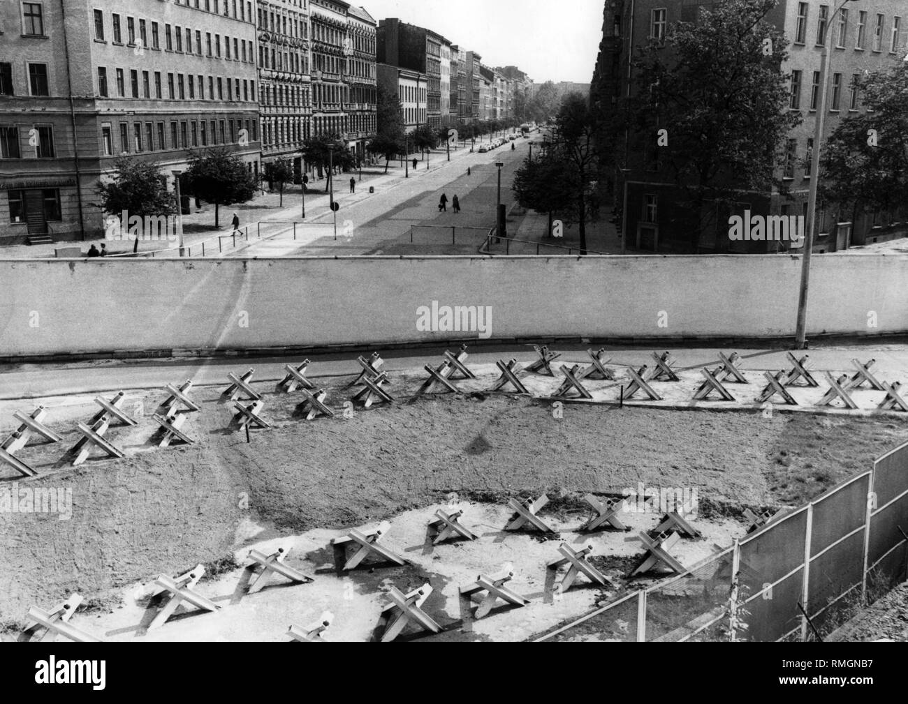 Überblick über die grenzbefestigung an der Sektorengrenze in Berlin. Mehrere Tanks Barrieren zwischen einer Wand und einem gitterzaun platziert. Im Hintergrund, West Berlin. Stockfoto
