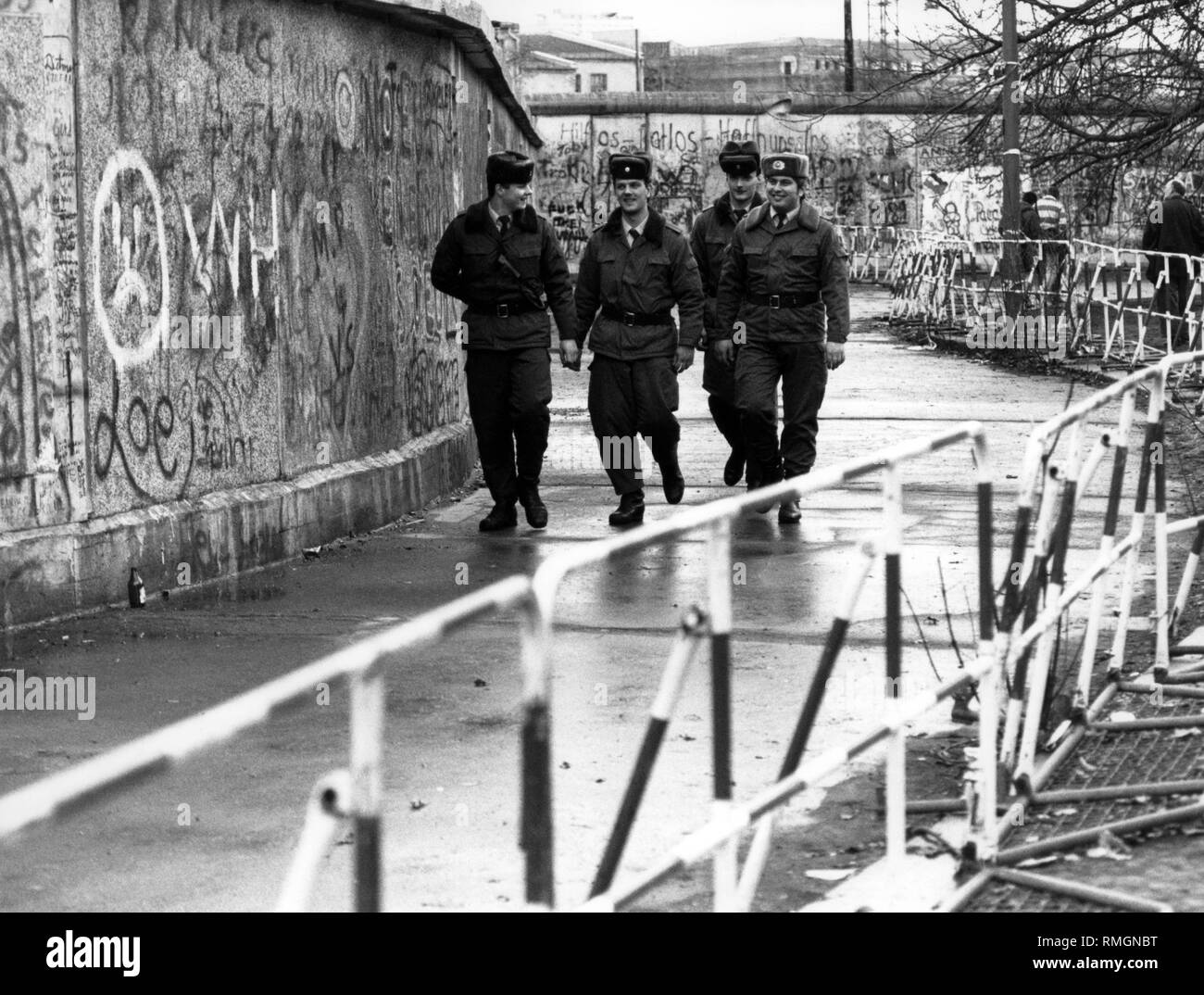 Grenzsoldaten der DDR führen ein Border Patrol auch nach der Öffnung der Berliner Mauer auf der Westseite des noch stehenden Wand. Stockfoto