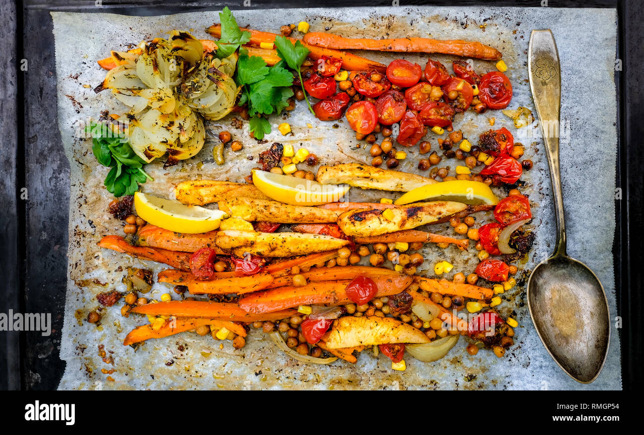 Pan-Roasted Huhn und Gemüse. Ansicht von oben, einfach essen. Stück Karotte, Brustfilet, Zwiebel, Süßkartoffel und Cocktailtomaten. Stockfoto