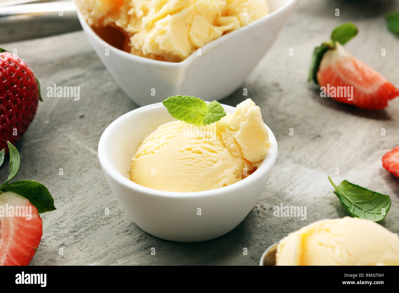 Vanilleeis mit frischen Erdbeeren und Eiscreme Kegel auf einem urigen Hintergrund Stockfoto