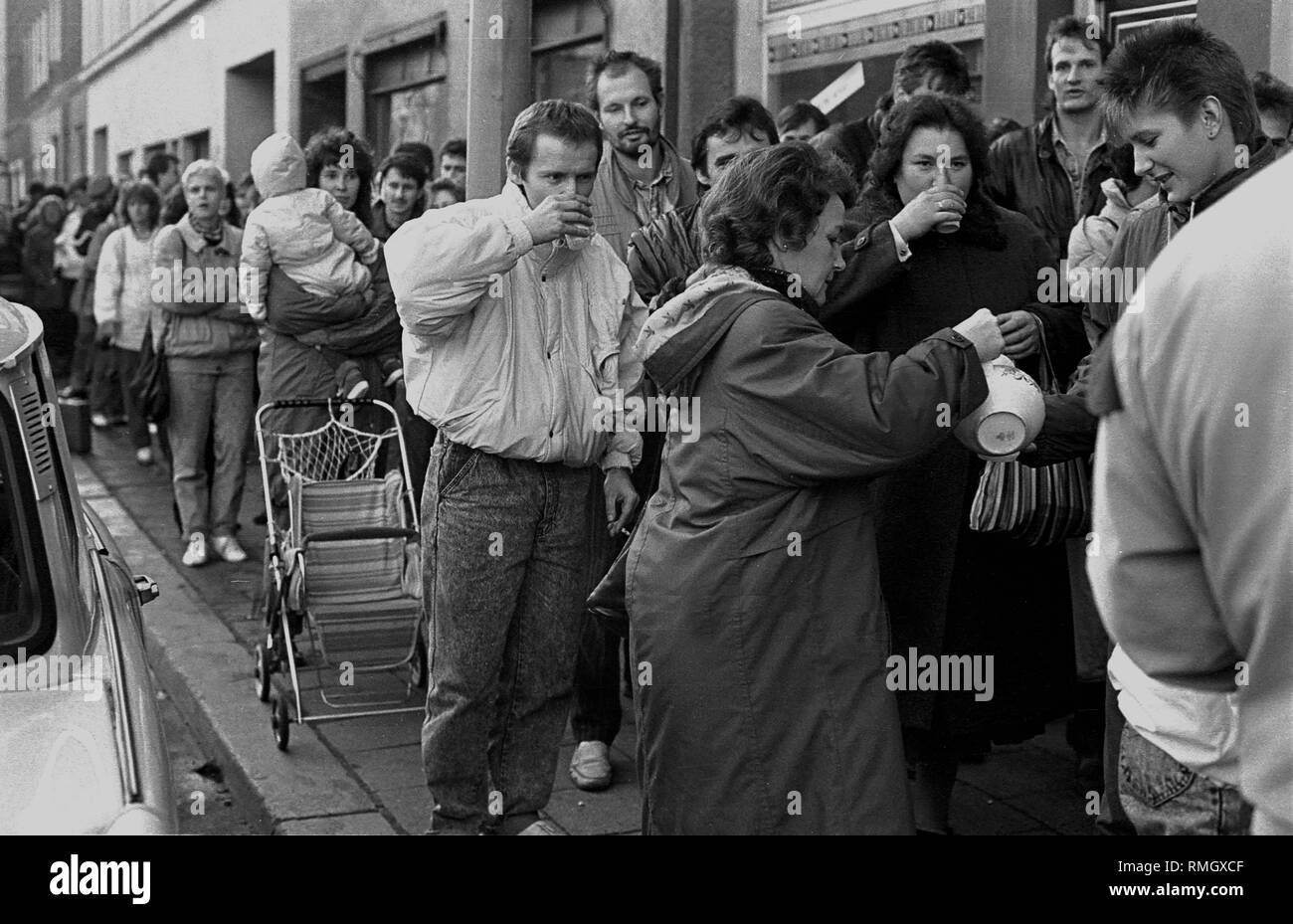 Nach der Öffnung der Berliner Mauer am 9. November, DDR-Bürger warten auf Ihr Visum in die Bundesrepublik Deutschland bei der Registration Office in Muenzstrasse. Sie sind mit warmen Getränken während der Wartezeit. Stockfoto