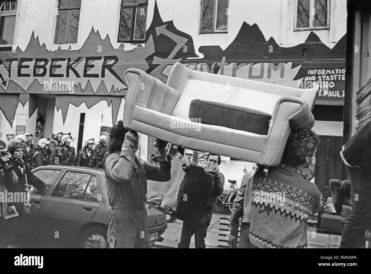 Mitarbeiter einer Baufirma leer einige Wohnungen und die Möbel aus der Stoertebeker center Transport unter Polizeischutz. Stockfoto