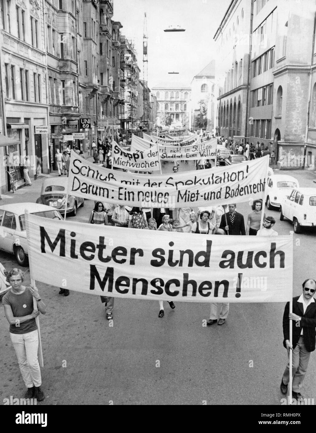 Nachweis Mieter März in der Amalienstraße. Auf der linken Seite der Straße, Antiquitätenhändler Robert Woelfle, Amalienstraße 65, und die Geschäfte: Buecher Bernsdorf und UNI 69. Im Hintergrund, die Akademie der Bildenden Künste, Akademiestraße. Auf den Banner: "Mieter auch Menschenrechte sind!', 'Stop Die Spekulation! Daher: Eine neue Miete und ein neues Land Gesetz', 'Weg mit der exorbitanten Mieten', 'Nicht Murren in der Stille, der Rat der Stadt ihr wird! ' Stockfoto