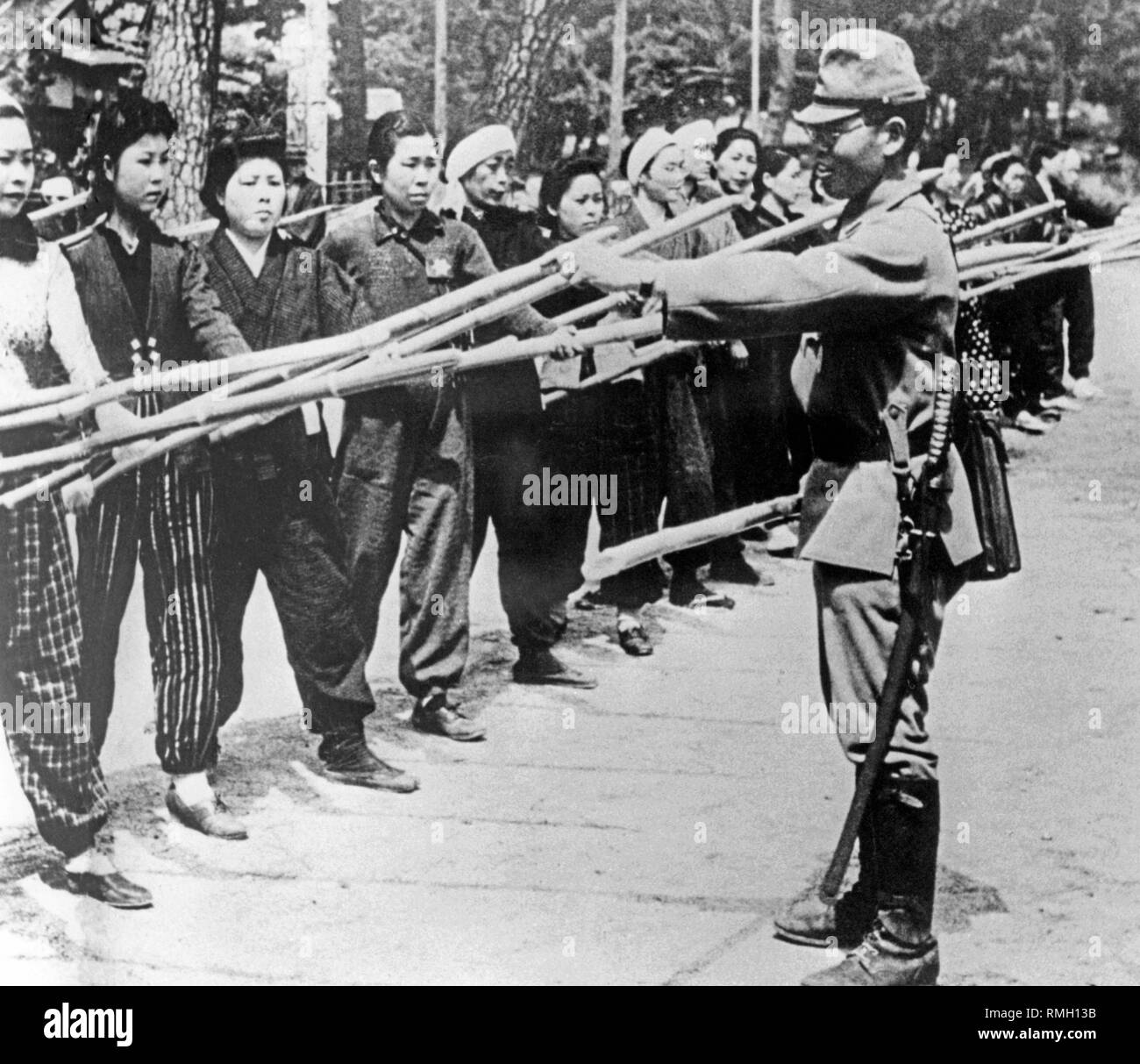 Ein Japanischer Offizier in der Armee während des Trainings mit Zivilisten. Sie sind Ausbildung Spears im Falle der zu erwartenden amerikanischen Invasion auf dem japanischen Heimat zu verwenden. Stockfoto