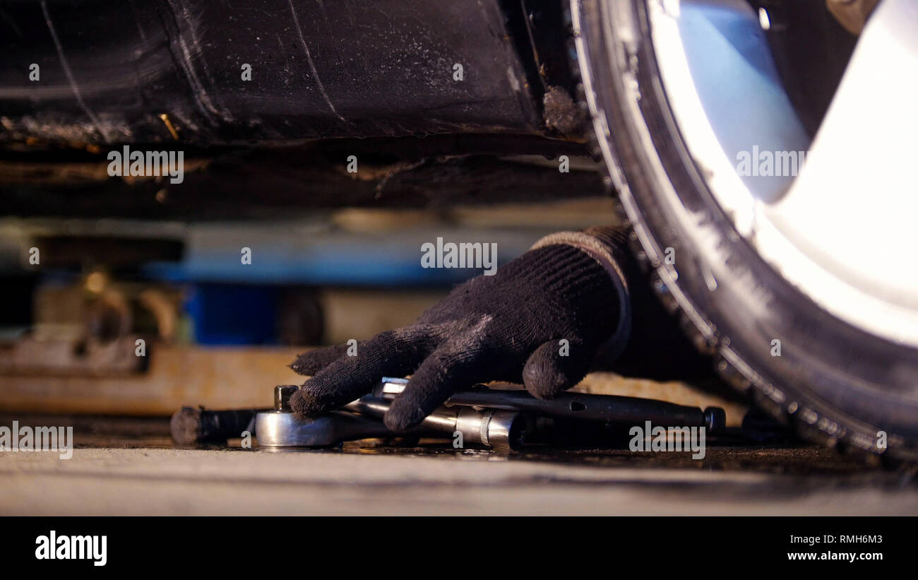 Car Service. Mechaniker Mann erreichen für ein Werkzeug Stockfoto
