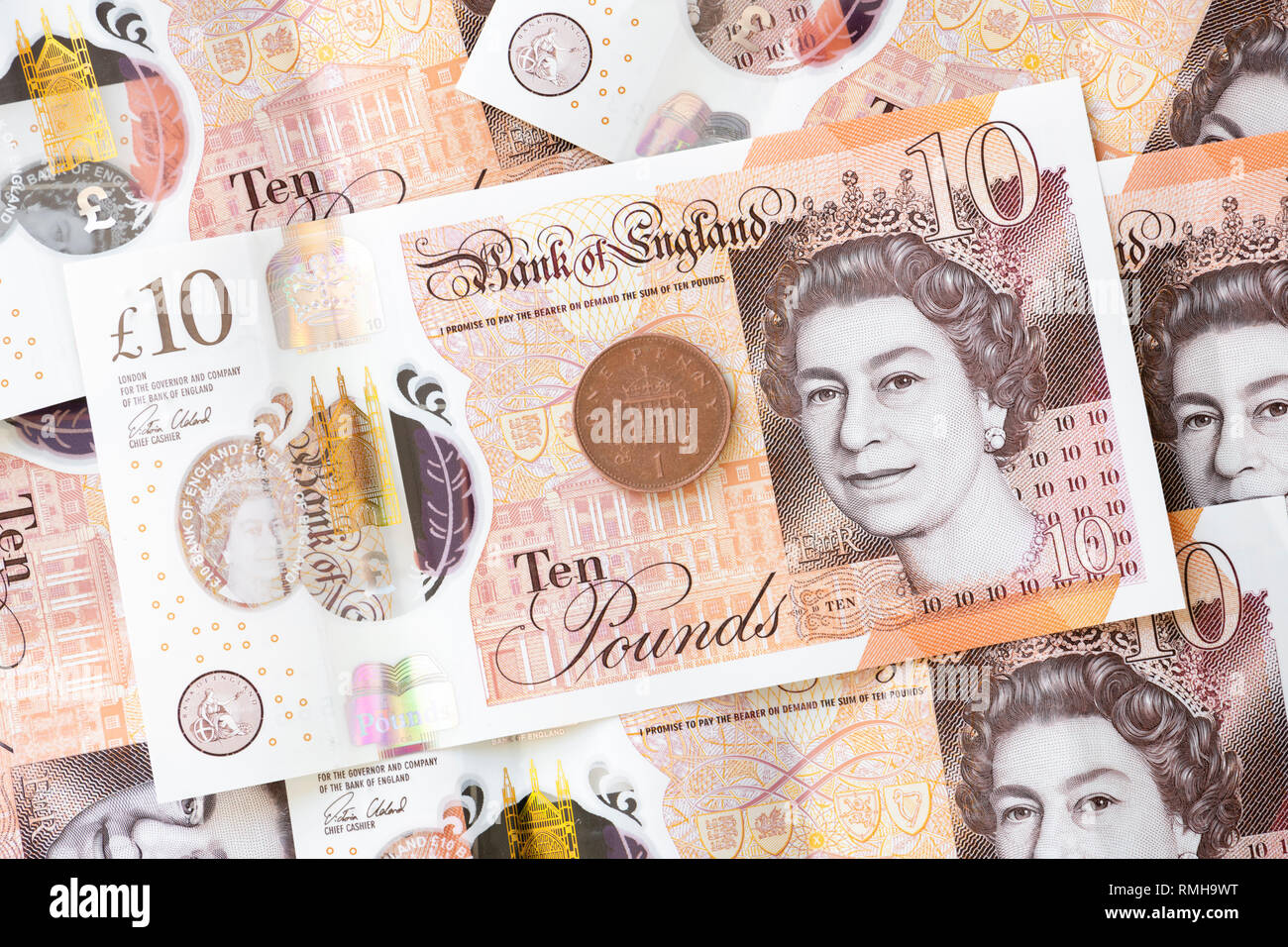Zehn Pfund Noten, England. UK Währung Bargeld GBP Bank Note mit einem Penny Münze 1 s. Stockfoto