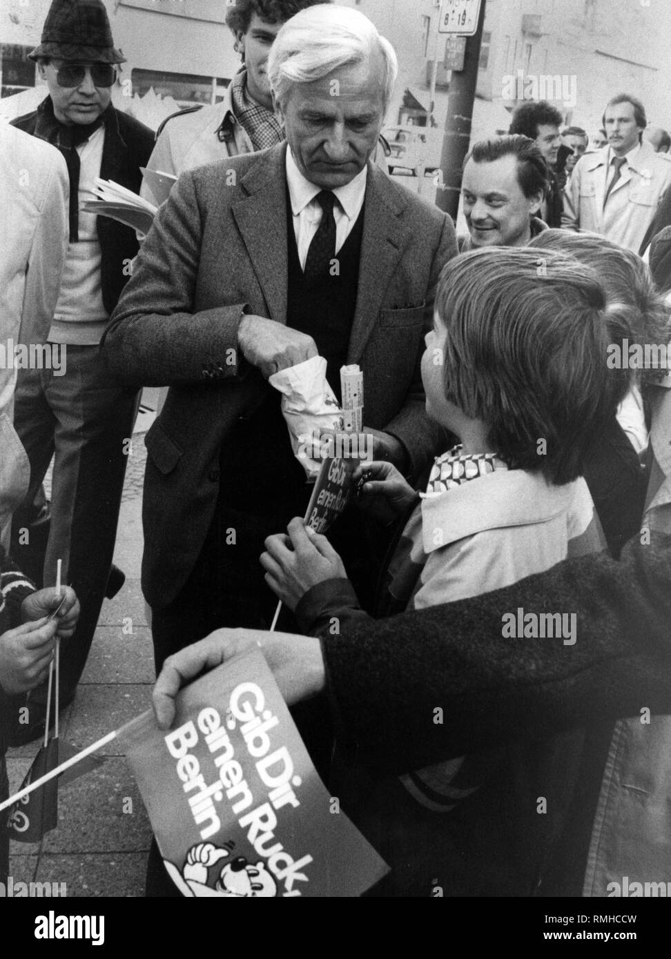 Undatiertes Foto von Richard von Weizsaecker, wie er Zucker Kinder während der Wahlkampf in Berlin. Stockfoto