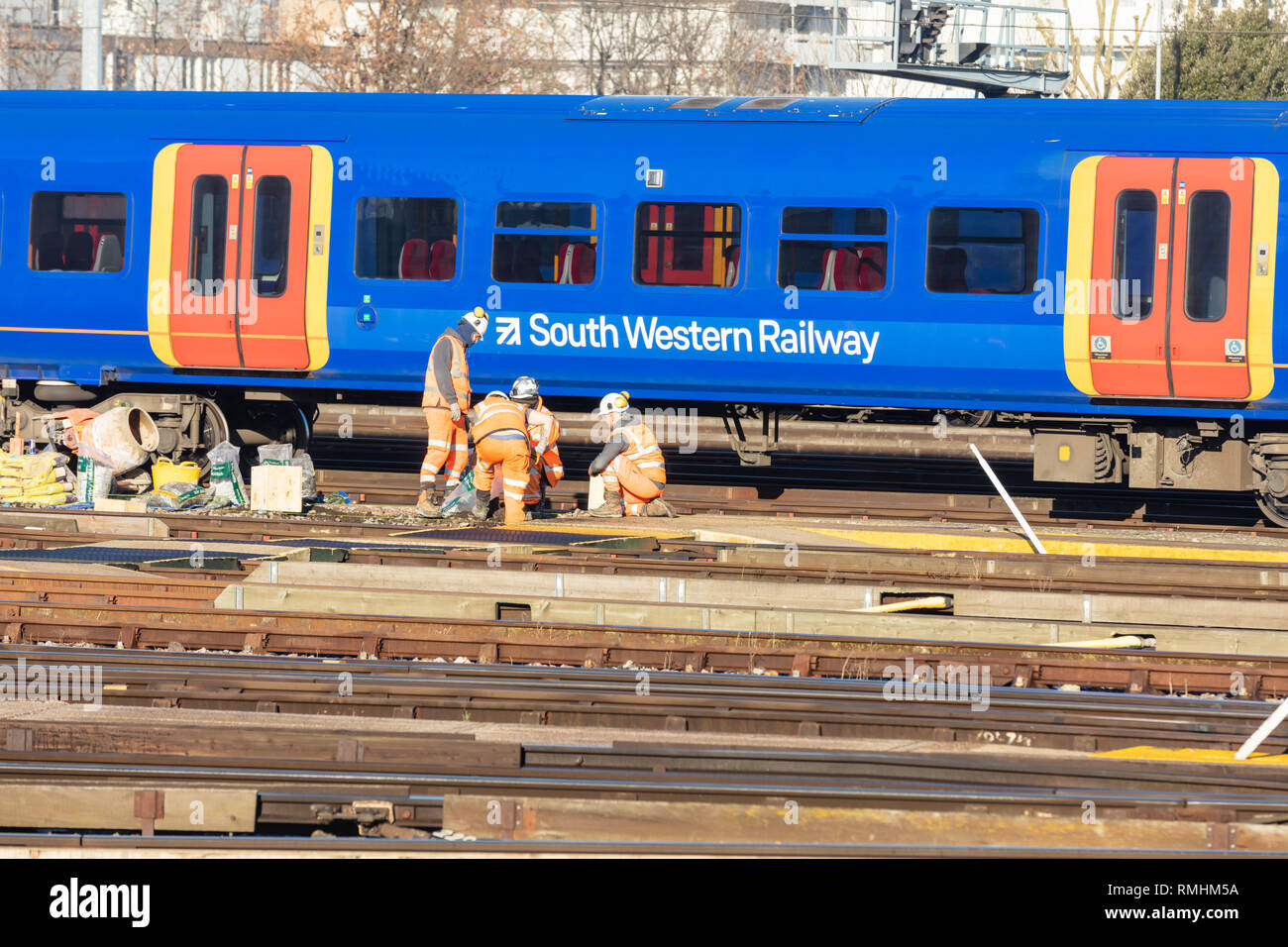 Clapham Junction, London, UK, 14. Februar 2019; Gruppe der Eisenbahner, die Strecke mit dem Zug hinter Stockfoto