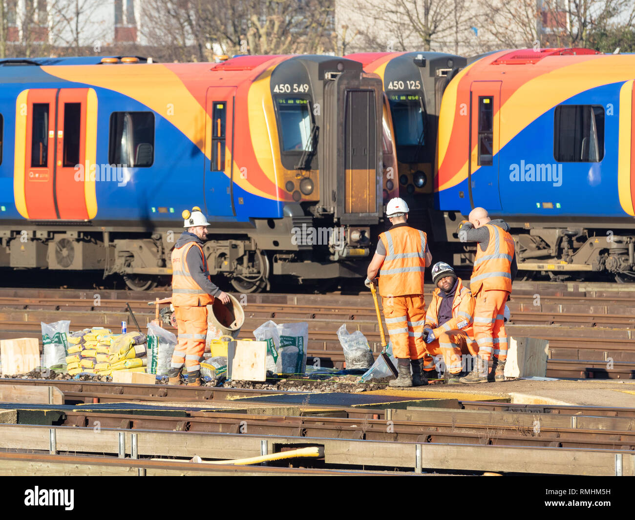 Clapham Junction, London, UK, 14. Februar 2019; Gruppe der Eisenbahner, die Strecke mit dem Zug hinter Stockfoto