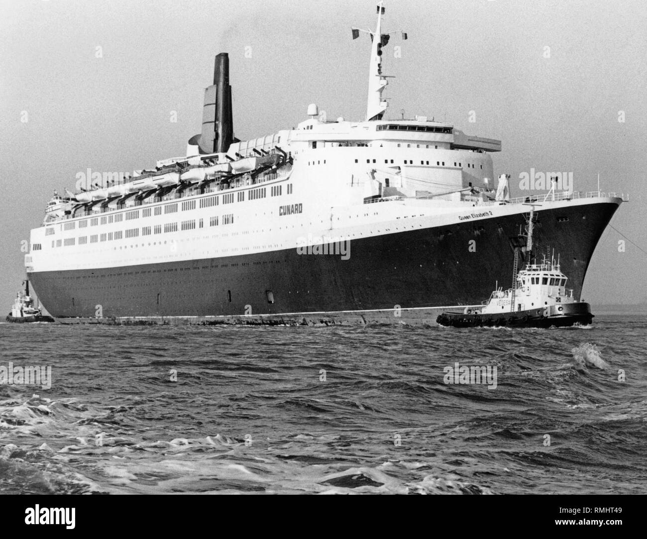 Die transatlantische Liner "Queen Elizabeth 2" der Cunard Reederei wird für den Wiederaufbau an der Lloyd Werft in Bremerhaven abgeschleppt. Stockfoto Die transatlantische Liner "Queen Elizabeth 2" der Cunard Reederei wird für den Wiederaufbau an der Lloyd Werft in Bremerhaven abgeschleppt. Stockfoto