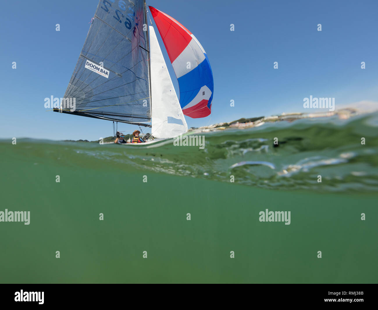 Eine Yacht segeln Vergangenheit während des Salcombe Stadt Regatta unter einem wunderschönen blauen Himmel. Stockfoto