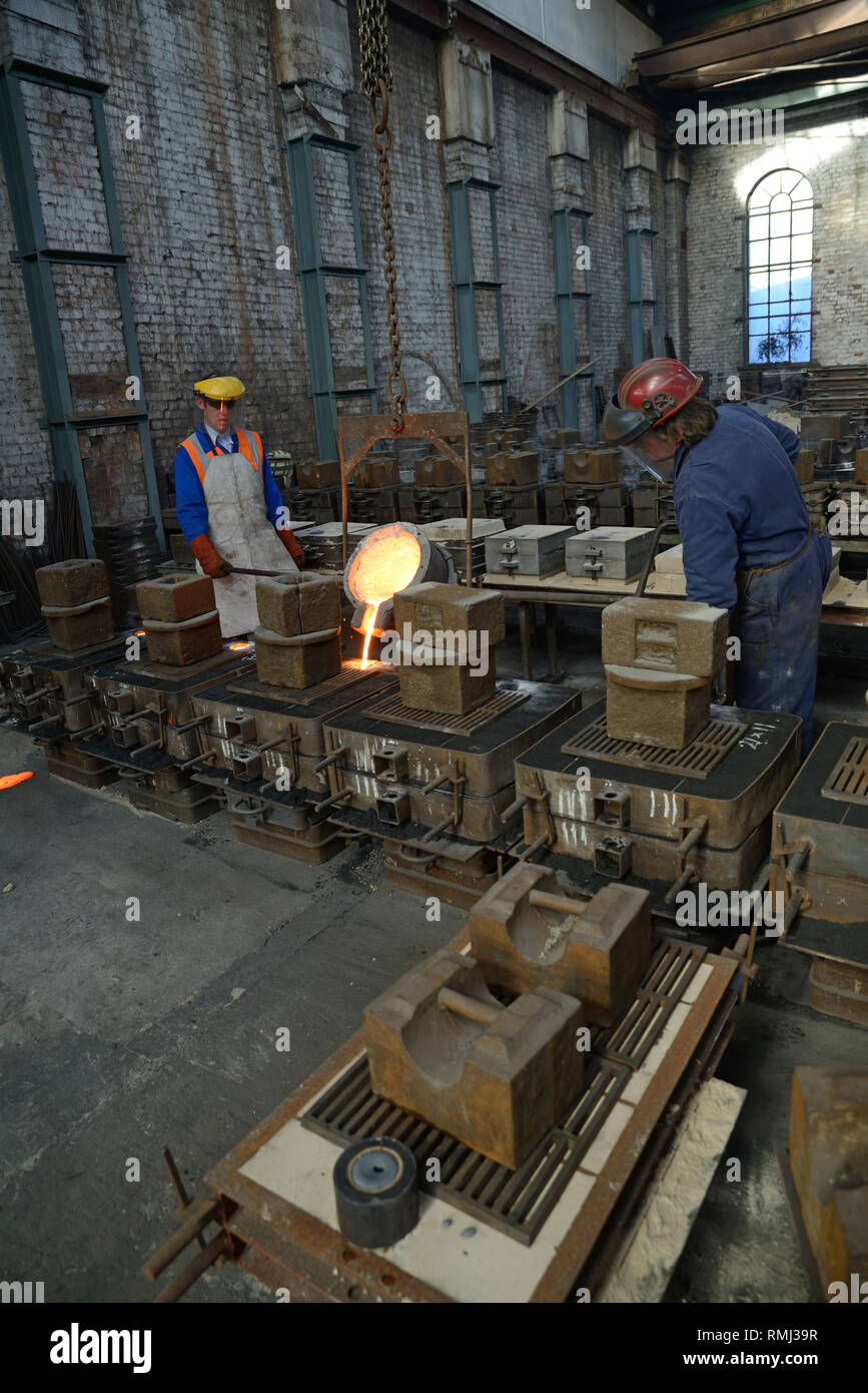 Gießer geschmolzenes Eisen in Formen für die Herstellung von Gitterrosten Feuer gießen Stockfoto