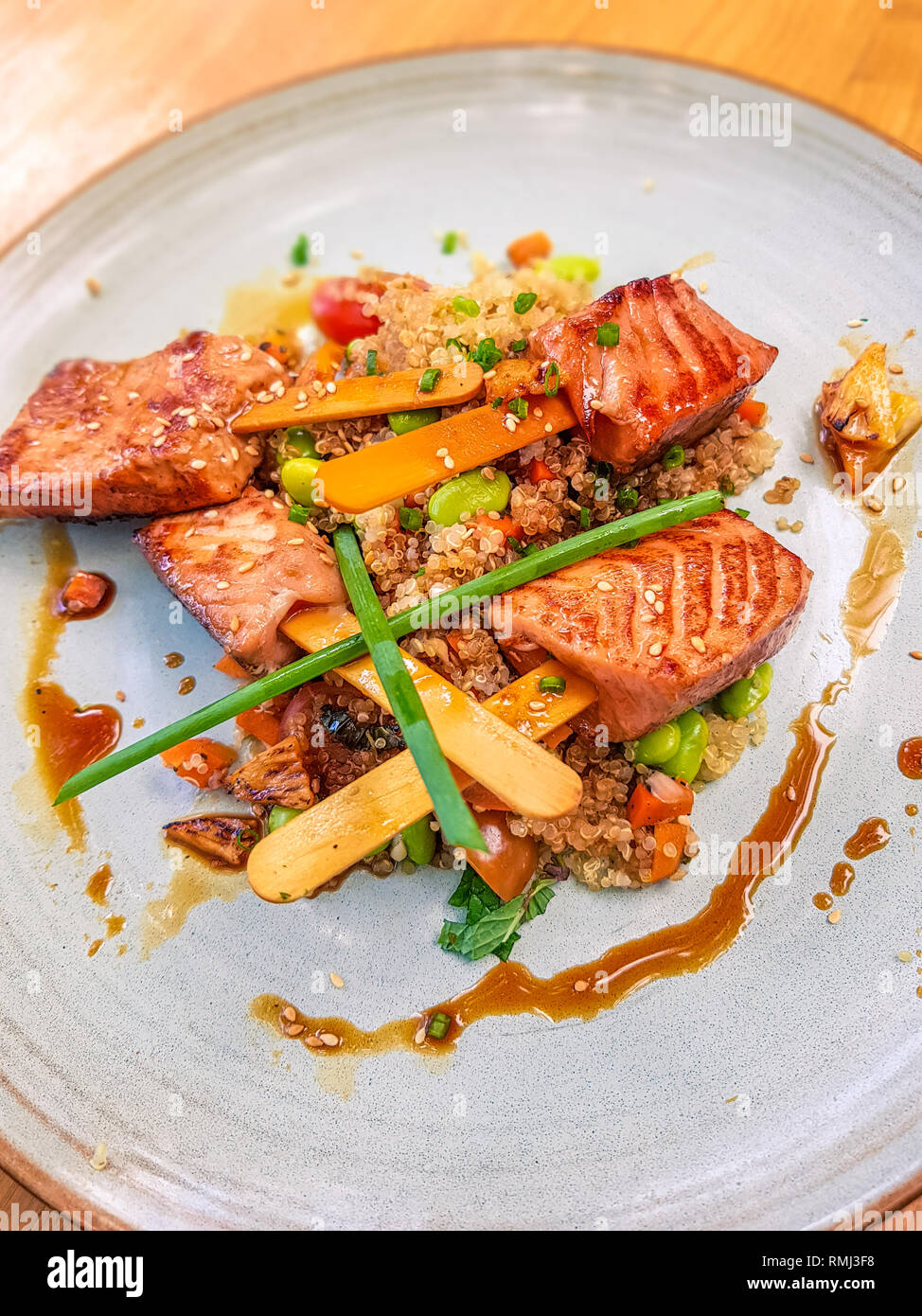 Lachs Eis wie Steaks auf dem Stick mit parboiled Quinoa und süße Asiatische Sauce serviert. Stockfoto