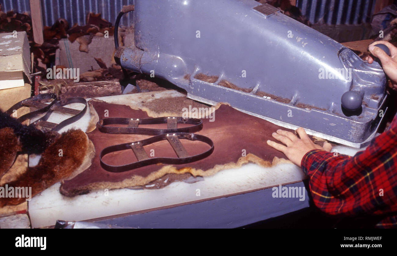 Ein Arbeitnehmer mit einem Klick auf die Taste mokassin Sohlen von possum Skins zu schneiden, Neuseeland, ca. 1993. Stockfoto