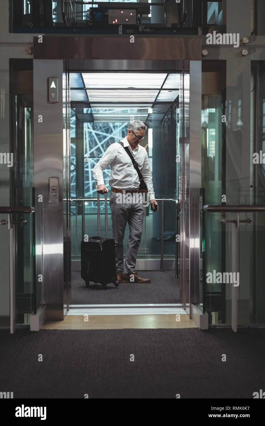 Geschäftsmann mit Reisekoffer im Aufzug Stockfoto