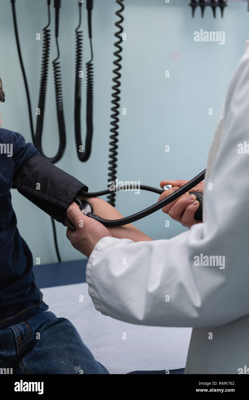 Jungen asiatischen männlicher Arzt Kontrolle Blutdruck der Kaukasischen jungen Patienten in der Klinik Stockfoto