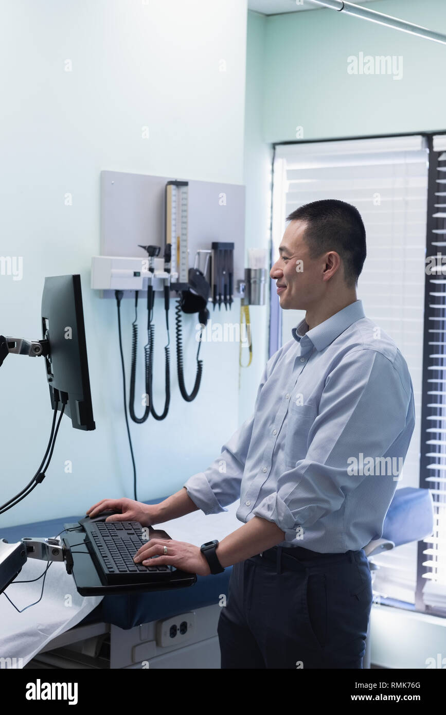 Jungen asiatischen männlicher Arzt Arbeiten am Computer in der Klinik Stockfoto