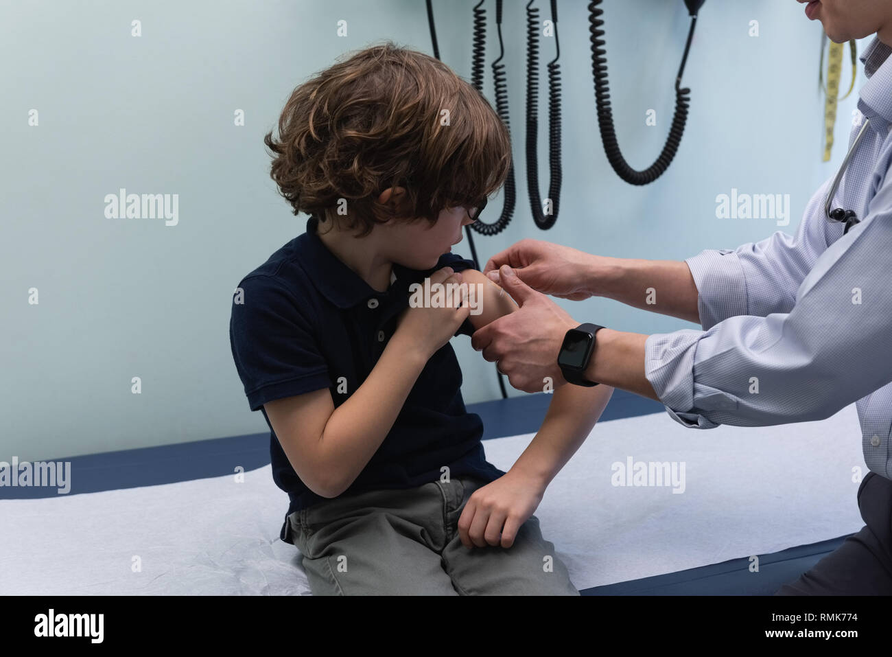 Jungen asiatischen männlicher Arzt spritzen Spritze mit kaukasischen jungen Patienten in der Klinik Stockfoto