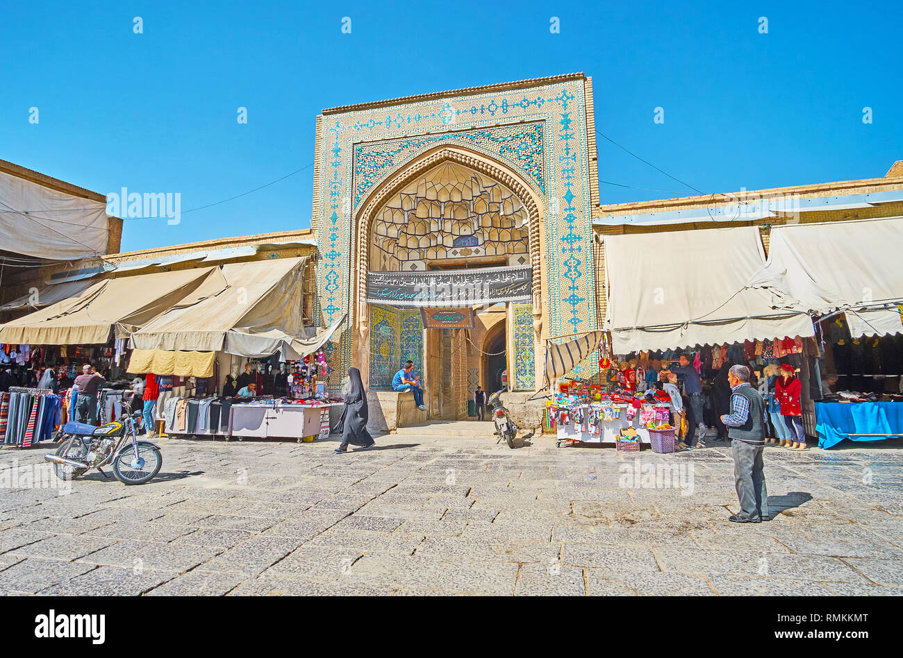 ISFAHAN, IRAN - 21. Oktober 2017: Die reich verzierten Portal der mittelalterlichen Jameh Moschee Nachbarn mit Großen Basar Läden und Ständen, am 21. Oktober in Isfahan. Stockfoto