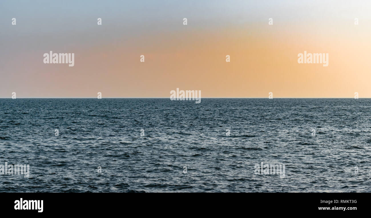 Schönes Foto von Marine kurz nach Sonnenuntergang mit klaren Horizont und ruhiges Meer Wasser. Die Farbe des Himmels nach Sonnenuntergang ist magisch. Täuschung der flachen Erde. Stockfoto