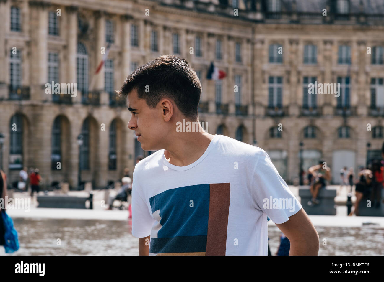 Junger Mann, der in der Wasser spiegel in Bordeaux gegen Stadtbild Stockfoto