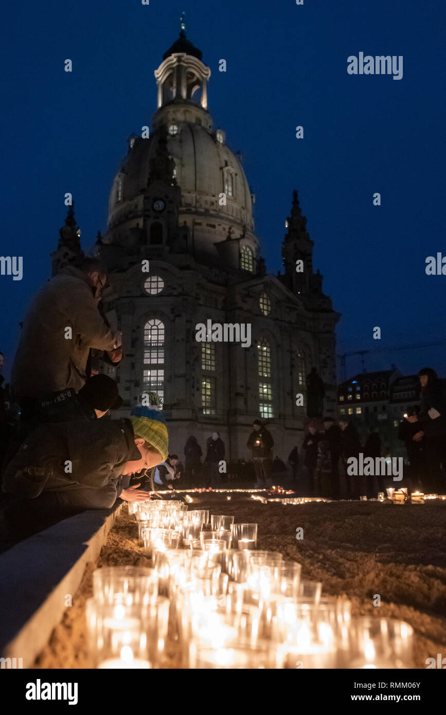 Neumarkt, Dresden, Sachsen, Deutschland. 13. Februar 2019. Ein junges Mädchen leuchtet eine Kerze vor der Frauenkirche, Dresden, Teil der Erinnerung Stockfoto