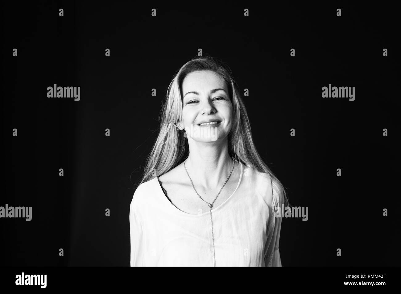 In der Nähe von Studio Portrait einer schönen Frau im weißen Kleid auf schwarzem Hintergrund Stockfoto