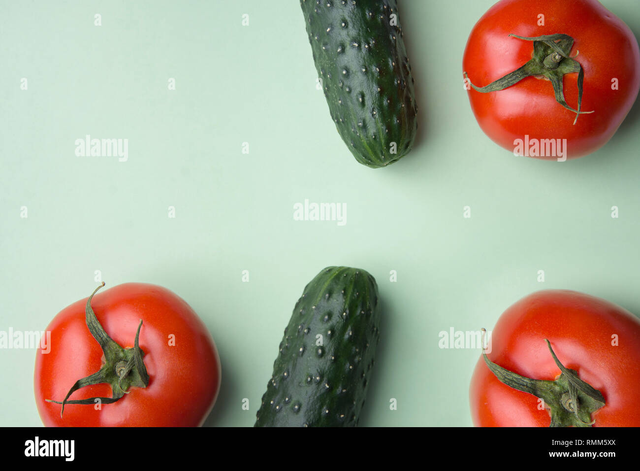 Roh Bio Tomaten Gurken auf leichten Salat mit grünem Hintergrund Reif. Ausgewogene Ernährung vegane Superfoods gesunder Lebensstil Konzept Vitamine. Kreative pos Stockfoto