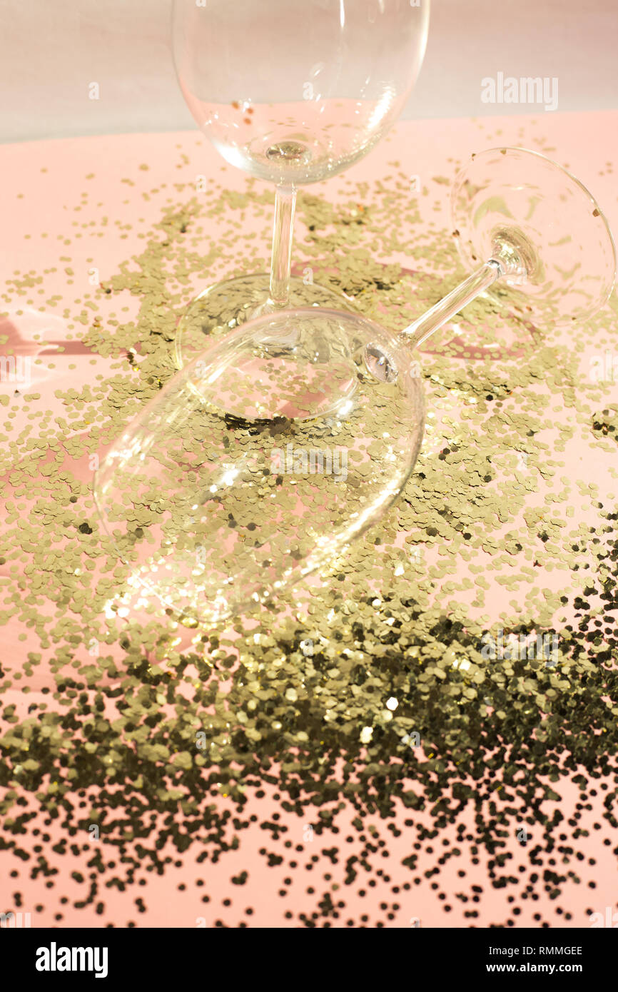 Leere Glas Pokale für Champagner im goldenen Konfetti auf dem Tisch. Festliche Hintergrund. Party Konzept. Stockfoto