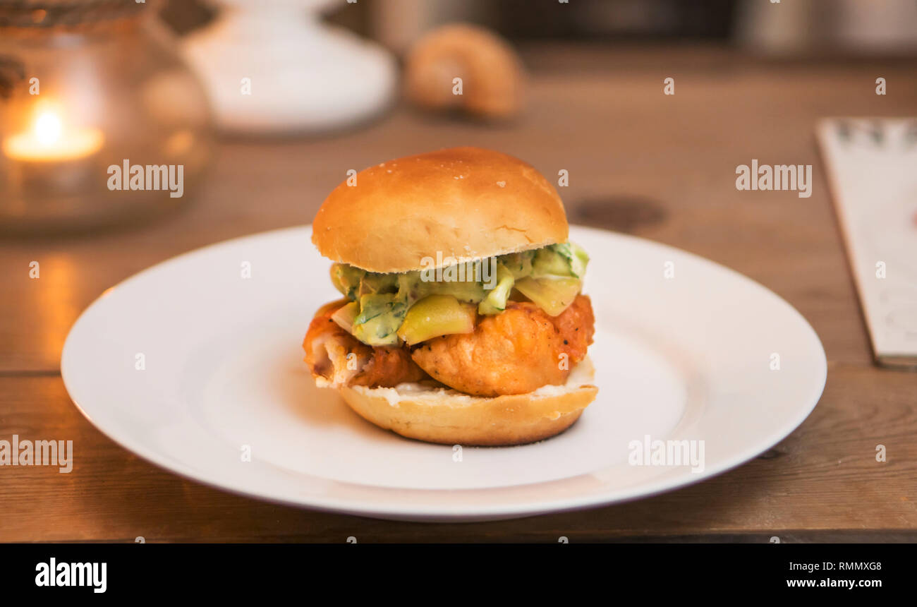 Fisch Sandwich, gebratener Kabeljau Burger mit süßen Gurke, Sauce Tartar, frische Brötchen, Kerzenlicht. Stockfoto