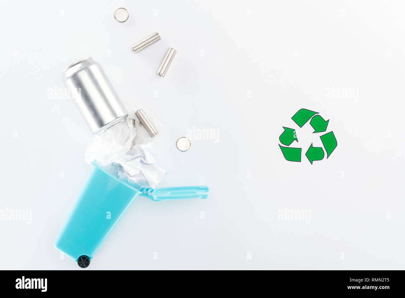 Batterien können und Papier in Spielzeug trashcan fallen auf grauem Hintergrund mit Recycling Symbol Stockfoto