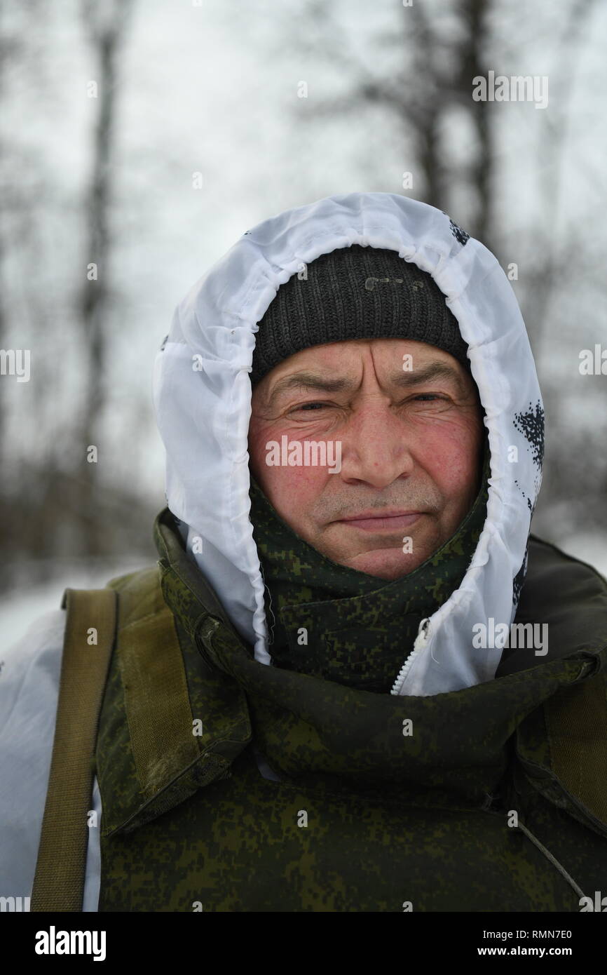 DPR Soldat, hiess, Dimitrie, gesehen im Schnee Camouflage und bullet proof Vest kurz vor wache Verschiebung an der Donezk Seite Front gekleidet. Der Krieg zwischen der ukrainischen Armee und die Soldaten der Donezk Volksrepublik hat das Leben von 12.000 Menschen und diejenigen, die vertrieben wurden mehr als eine Million. Das im Jahr 2014 eskaliert. Trotz eines Waffenstillstandes im Ort, es ist offensichtlich, dass der Tod immer noch Auftritt von vorwiegend, Sniper, Mörtel und Minen. Der Bau von Schützengräben auf beiden Seiten von Niemandsland, (oft nur 100 m auseinander) haben eine statische noch aggressiver Konfrontation gewährleistet. Th Stockfoto