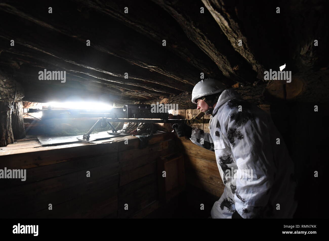Ein fuchsloch Lookout aus den Schützengräben auf dem DPR Seite des ukrainischen Konflikt. Niemandsland können so nahe wie 100 Meter. Ein Soldat aus der DPR Shakhtyorsk gesehen bereit, mit einem leichten Maschinengewehr. Der Krieg zwischen der ukrainischen Armee und die Soldaten der Donezk Volksrepublik hat das Leben von 12.000 Menschen und diejenigen, die vertrieben wurden mehr als eine Million. Das im Jahr 2014 eskaliert. Trotz eines Waffenstillstandes im Ort, es ist offensichtlich, dass der Tod immer noch Auftritt von vorwiegend, Sniper, Mörtel und Minen. Der Bau von Schützengräben auf beiden Seiten von Niemandsland, (oft nur 100 m auseinander) haben sichergestellt Stockfoto