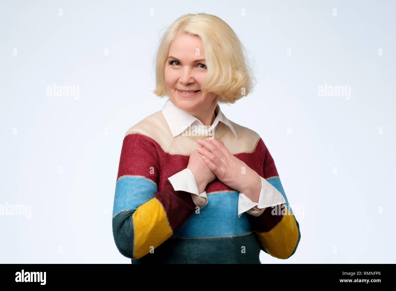 Schöne ältere Frau mit farbigen Pullover ist mit Kompliment berührt Stockfoto