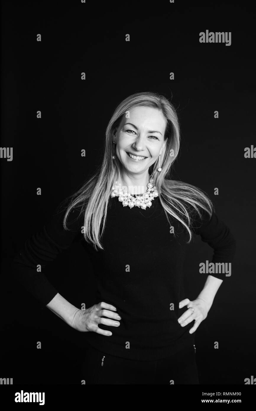 In der Nähe von Studio Portrait einer schönen Frau im schwarzen Kleid auf schwarzem Hintergrund Stockfoto