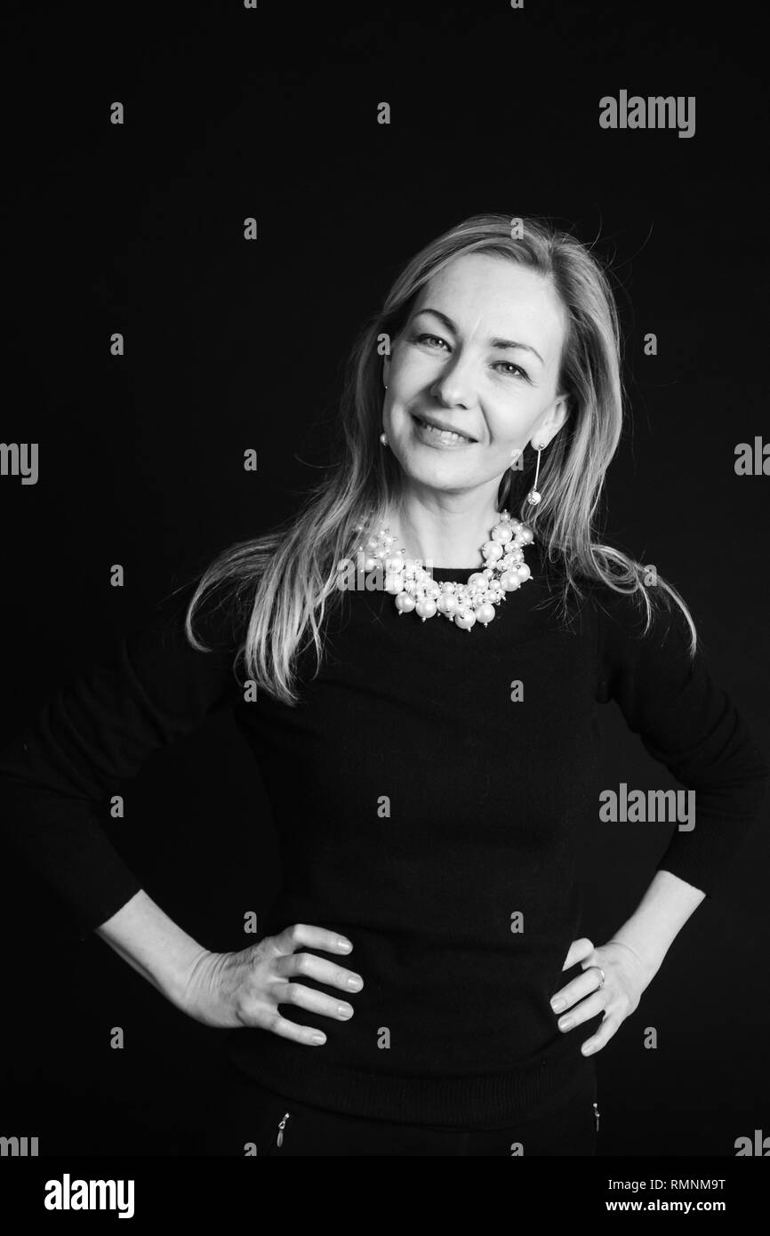 In der Nähe von Studio Portrait einer schönen Frau im schwarzen Kleid auf schwarzem Hintergrund Stockfoto