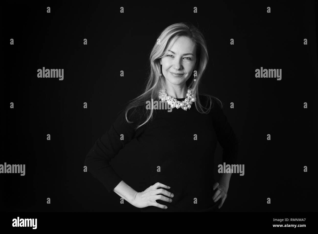 In der Nähe von Studio Portrait einer schönen Frau im schwarzen Kleid auf schwarzem Hintergrund Stockfoto