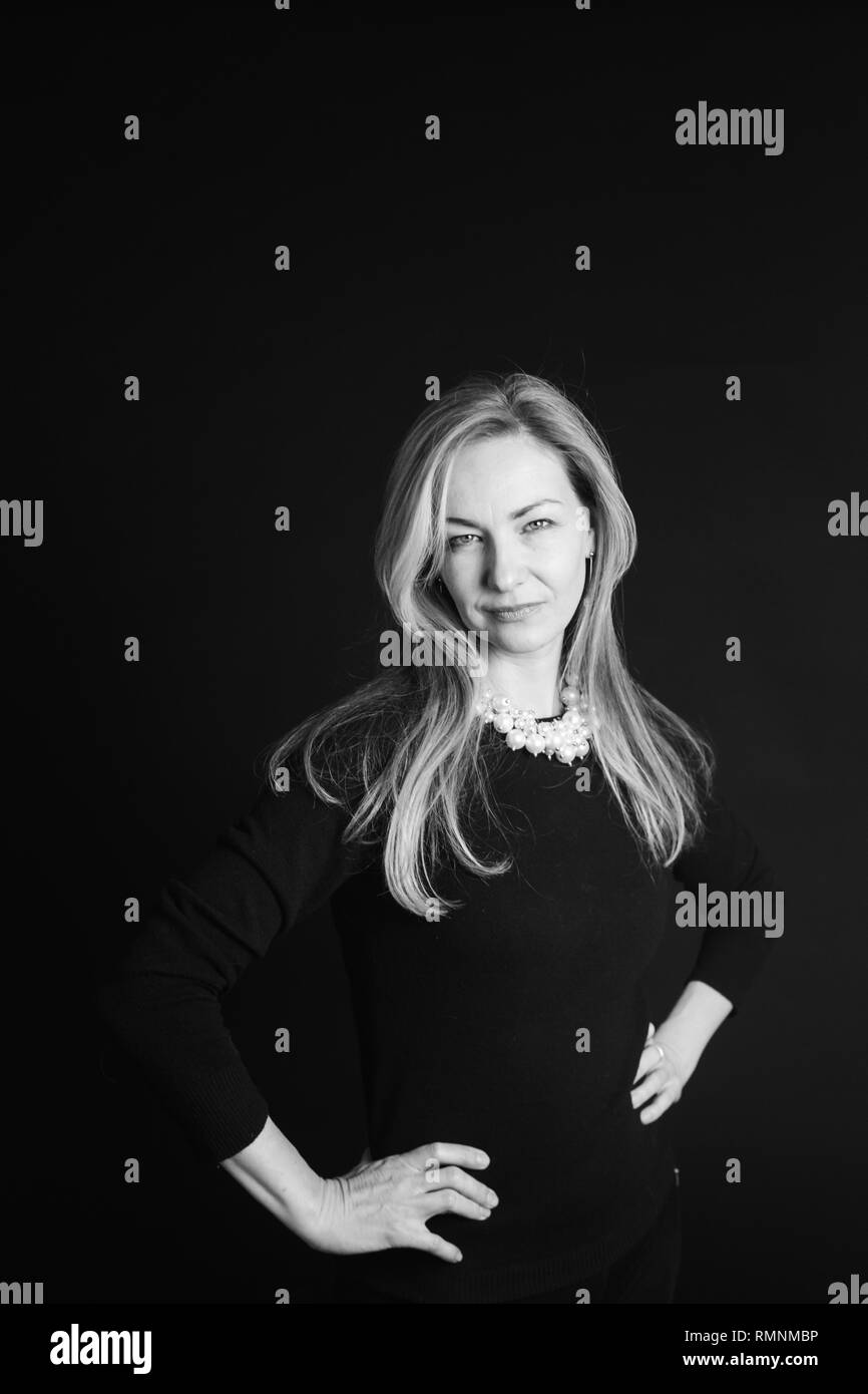 In der Nähe von Studio Portrait einer schönen Frau im schwarzen Kleid auf schwarzem Hintergrund Stockfoto
