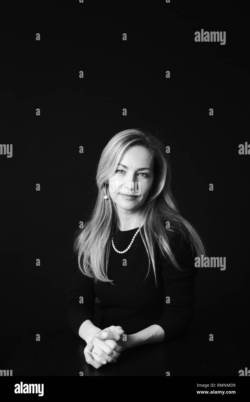 In der Nähe von Studio Portrait einer schönen Frau im schwarzen Kleid auf schwarzem Hintergrund Stockfoto