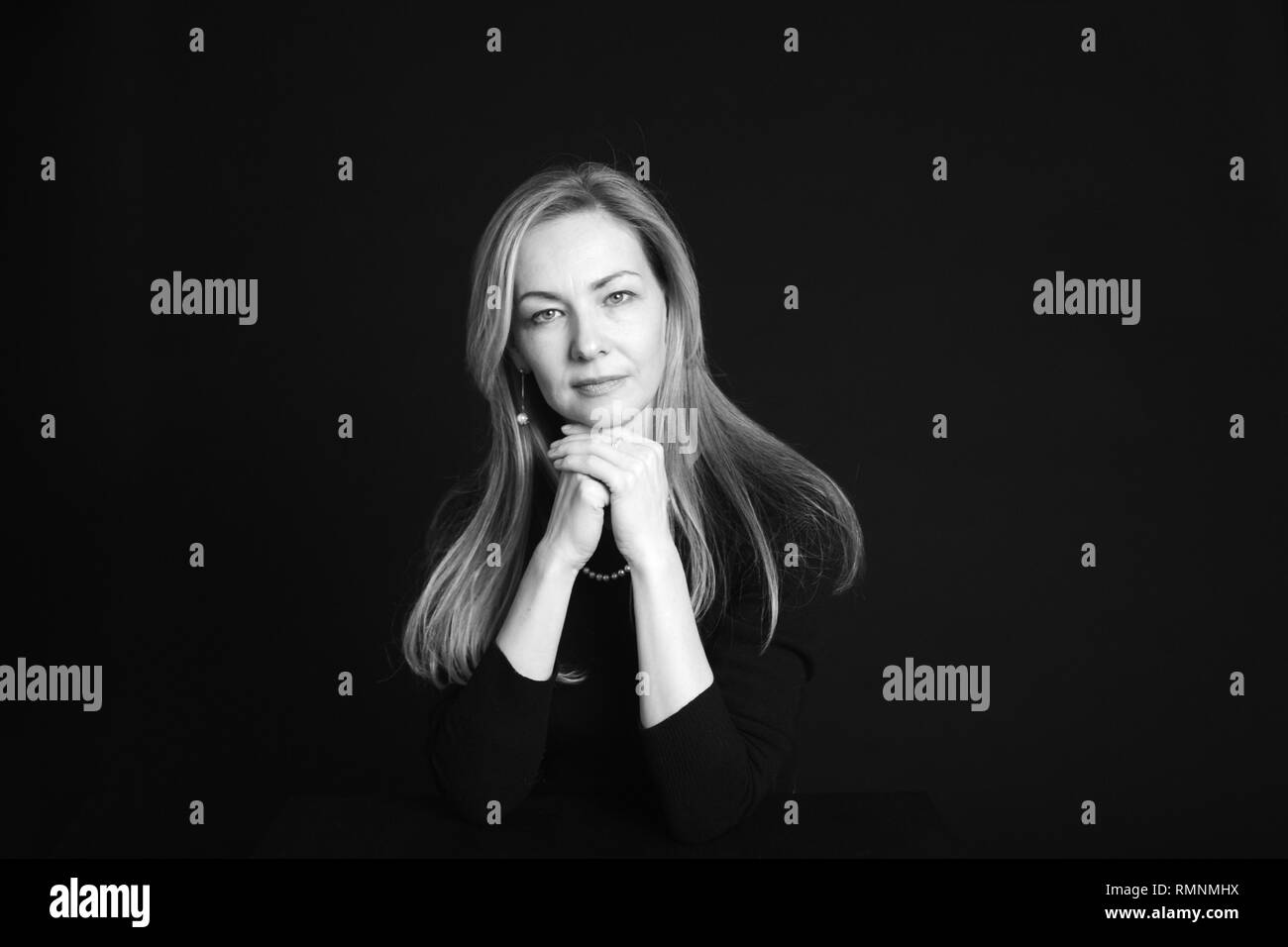 In der Nähe von Studio Portrait einer schönen Frau im schwarzen Kleid auf schwarzem Hintergrund Stockfoto
