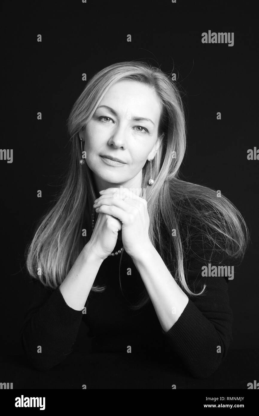 In der Nähe von Studio Portrait einer schönen Frau im schwarzen Kleid auf schwarzem Hintergrund Stockfoto
