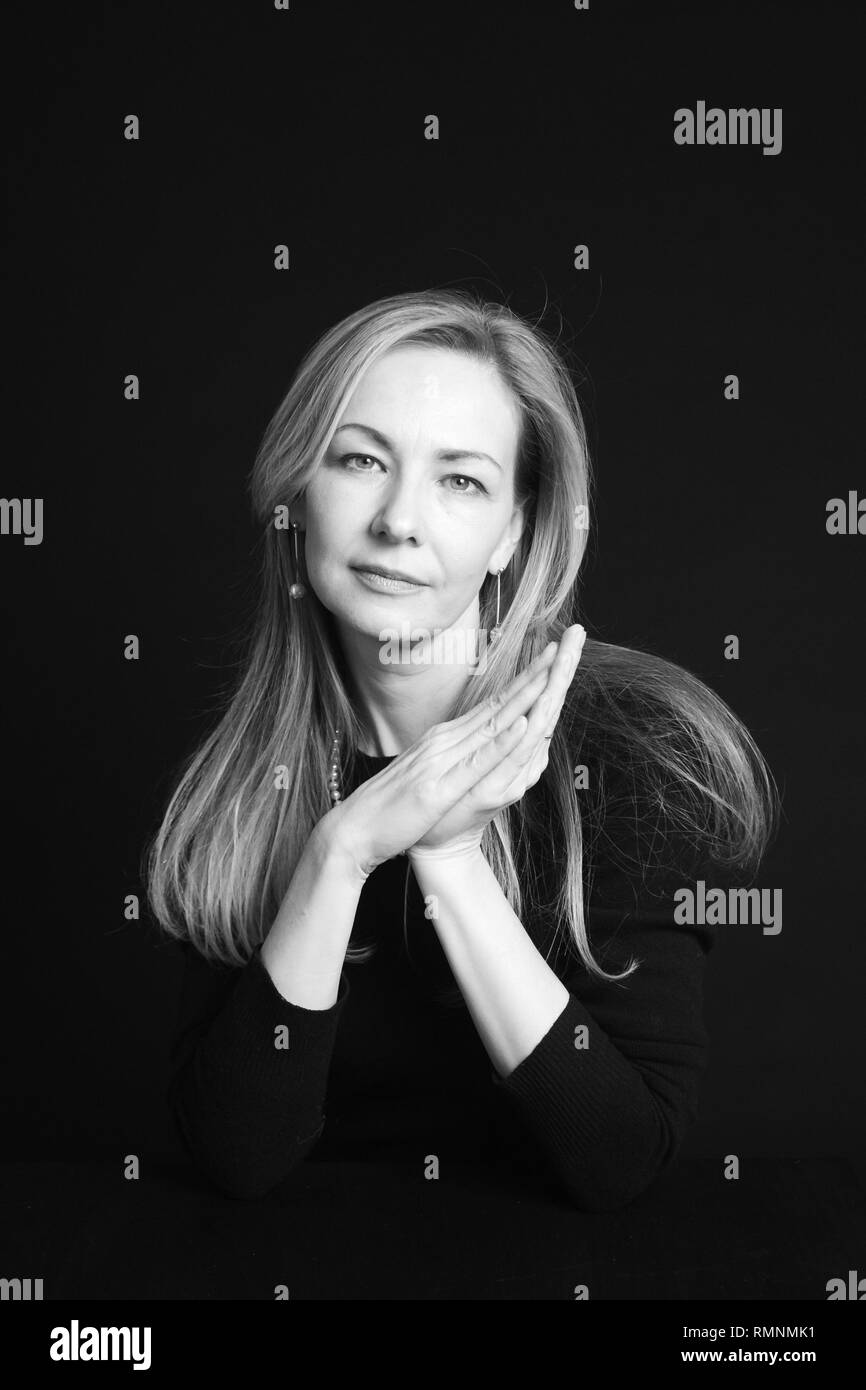 In der Nähe von Studio Portrait einer schönen Frau im schwarzen Kleid auf schwarzem Hintergrund Stockfoto