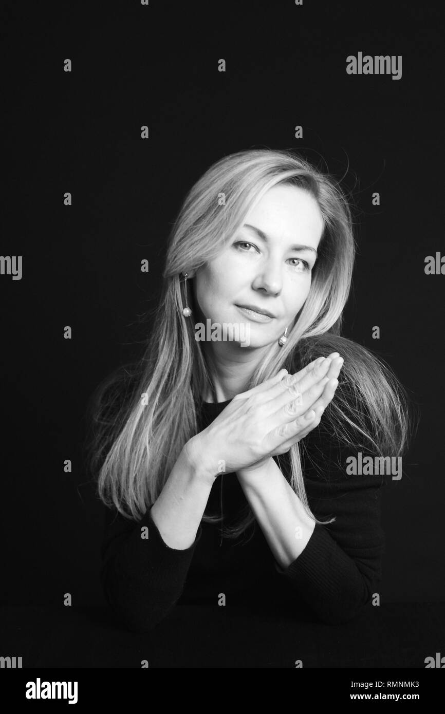 In der Nähe von Studio Portrait einer schönen Frau im schwarzen Kleid auf schwarzem Hintergrund Stockfoto
